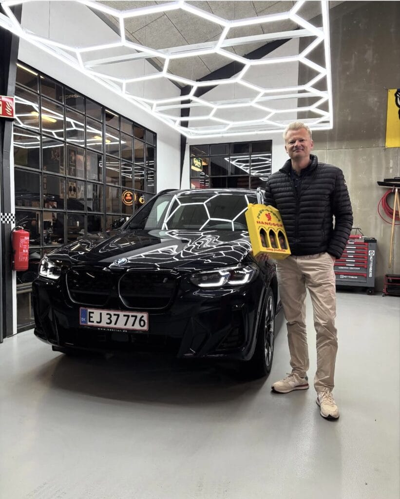 Mand står ved sort BMW i garage